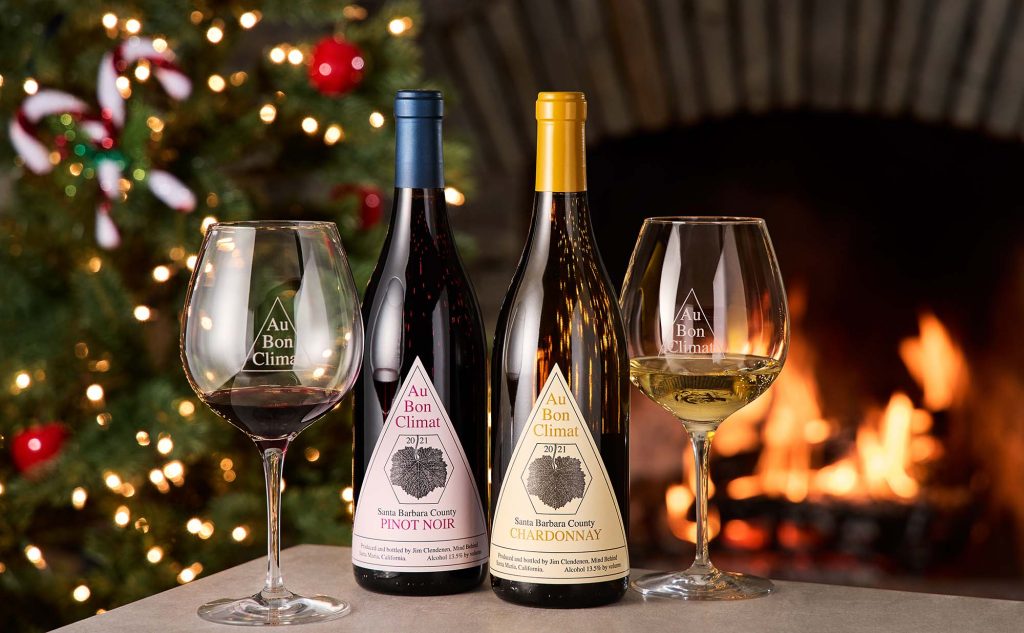 Au Bon Climat's Candy Cane Wine Gift Set - a bottle of red wine and a bottle of white wine in front of the fireplace and the Christmas tree