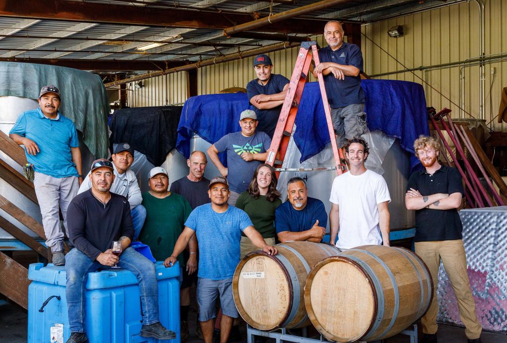 2023 Harvest Crew posing for a team photo in the Au Bon Climat and Clendenen Family Vineyards production area at the winery in Santa Maria