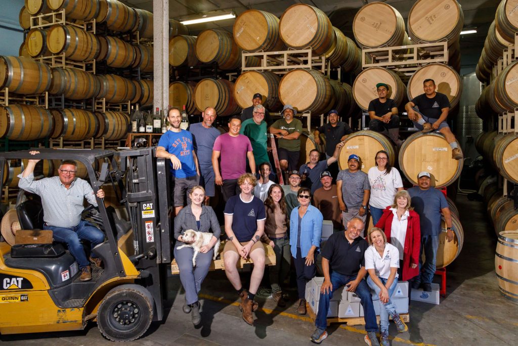 The Winery Team in front of barrel racks on the production floor at Au Bon Climat and Clendenen Family Vineyards