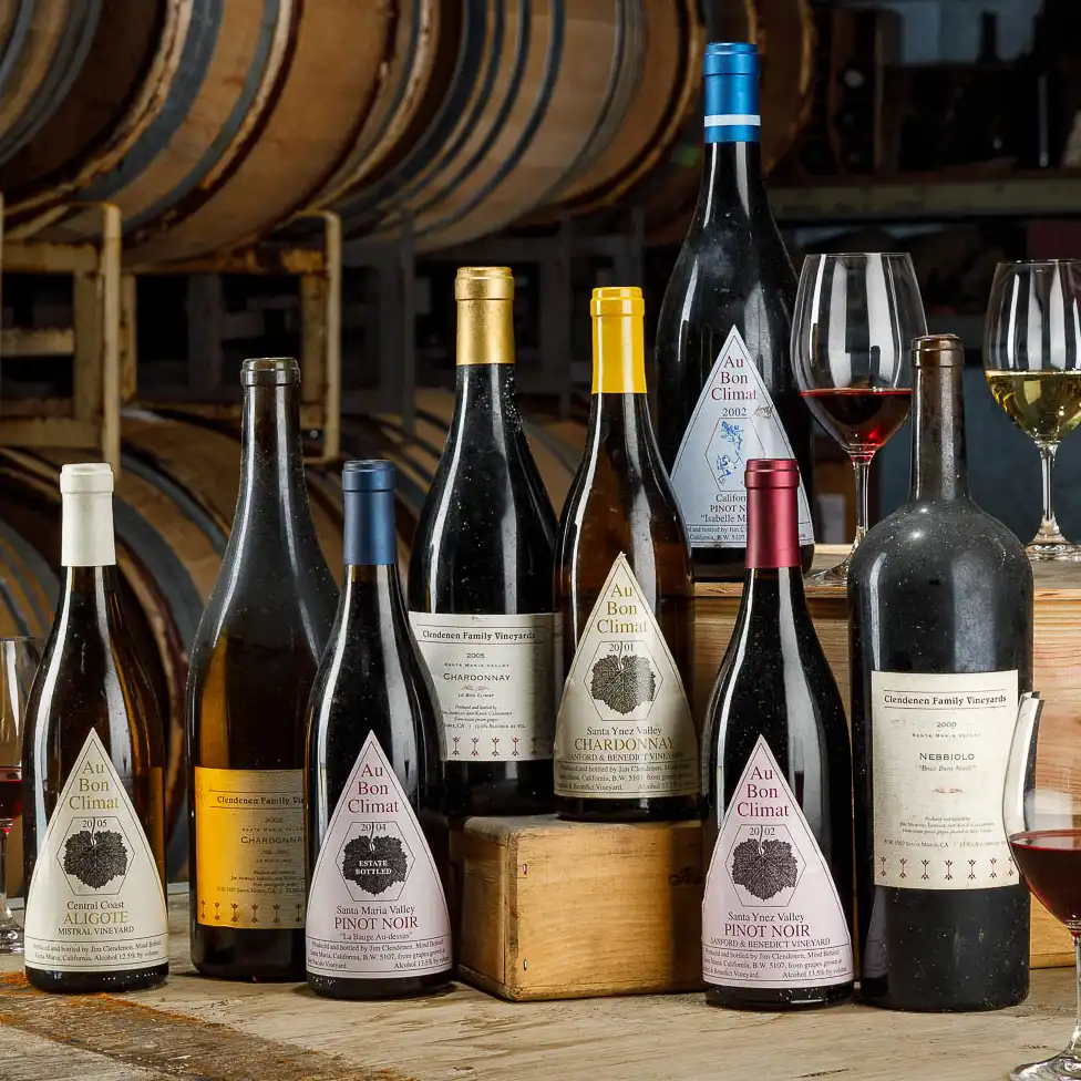 Au Bon Climat and Clendenen Family Vineyards bottles arranged on a wood table at the winery in Santa Maria