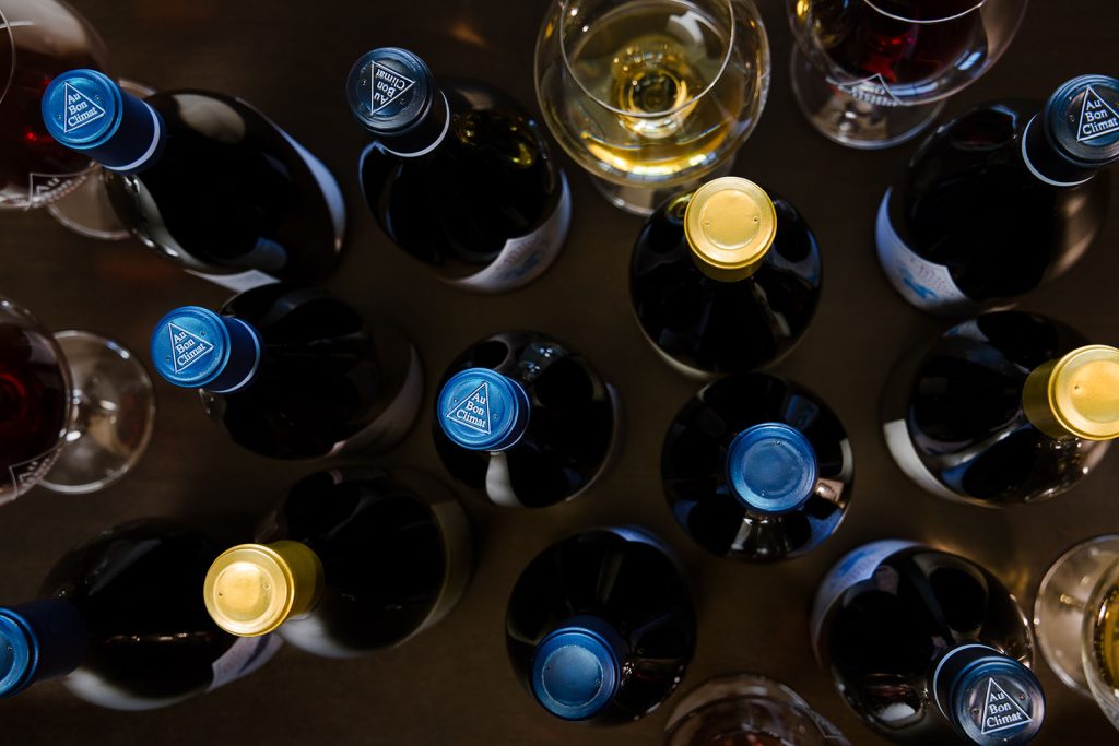 Bottles of Au Bon Climat wine viewed from the top showing embossed capsules with the Au Bon Climat logo on the top.