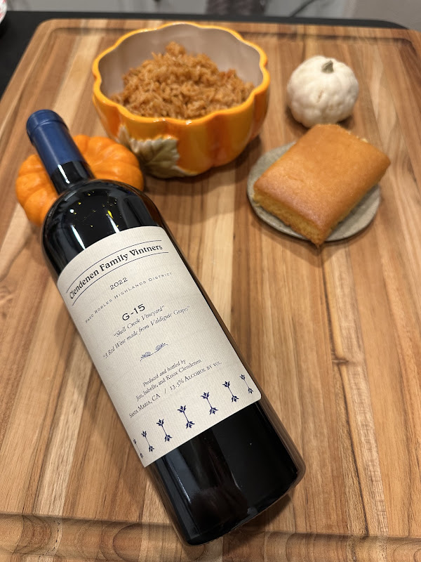 Bottle of Clendenen Family Vineyards 2022 G15 red wine paired with a golden slice of cornbread and holiday stuffing, surrounded by miniature pumpkins.